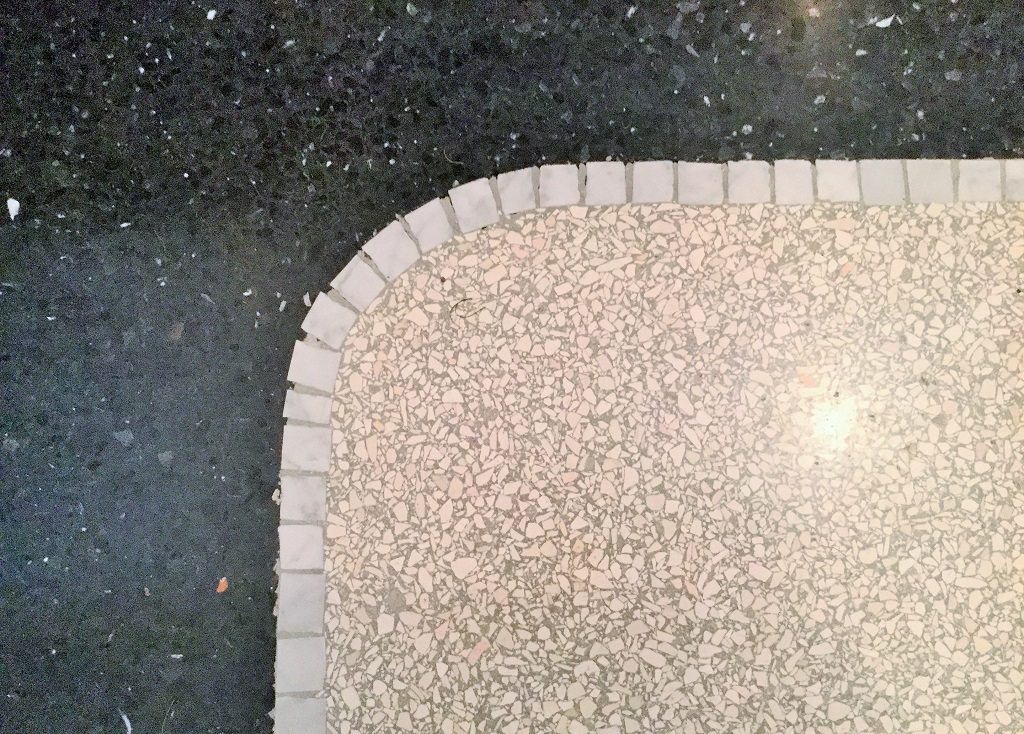 Eckdetail heller Terrazzo mit dunklem Fries und Mosaikstreifen