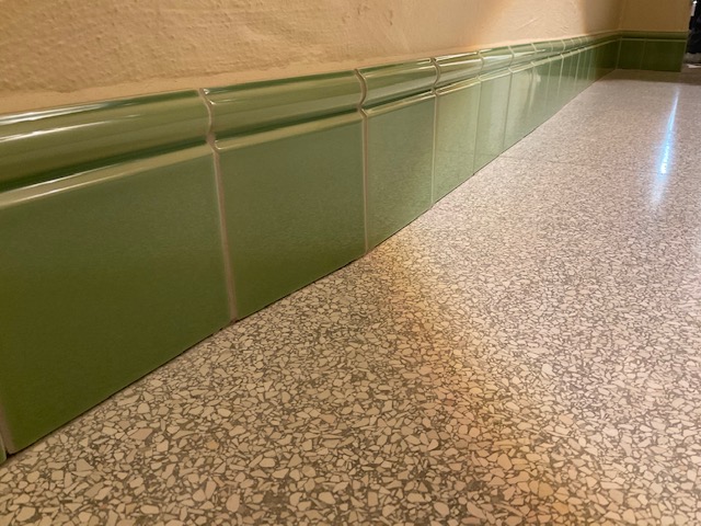 Sockeldetail heller Terrazzo im Waschraum mit grünen Wänden
