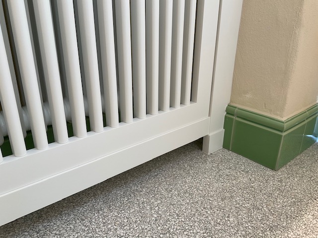 Ausführungsdetail heller Terrazzo im Waschraum mit grünen Wänden