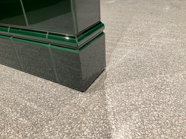 Ausführungsdetail heller Terrazzo im Waschraum mit grünen Wänden