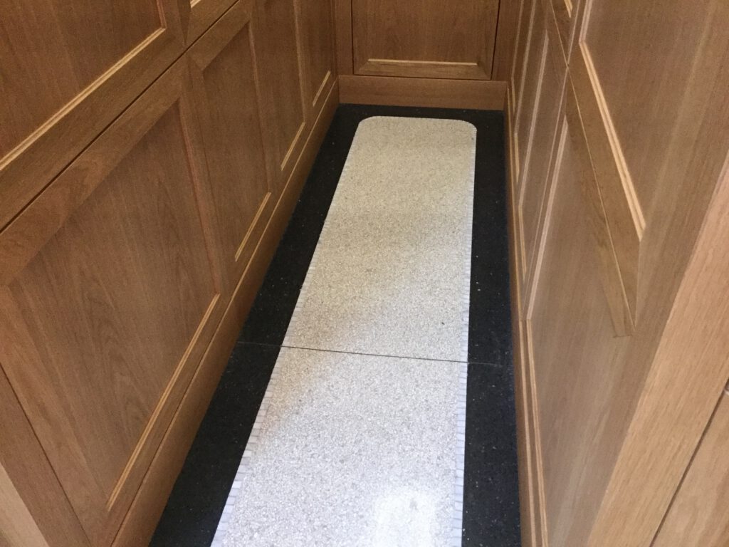 heller Terrazzo mit schwarzem Fries Wandvertäfelung aus Holz