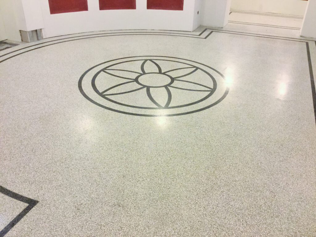 heller Terrazzo mit schwarzem Emblem