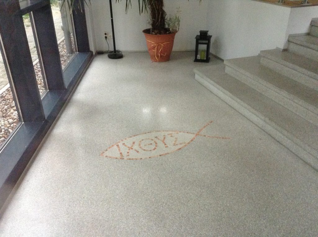 Foyer mit hellem Terrazzo und Emblem